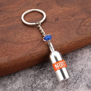 Macro detail of metal NOS nitrous bottle keychain with blue valve on wooden surface