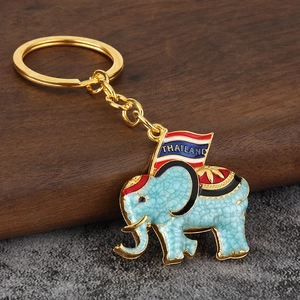 Macro detail of Thai elephant keychain with blue crackle glaze and Thailand flag