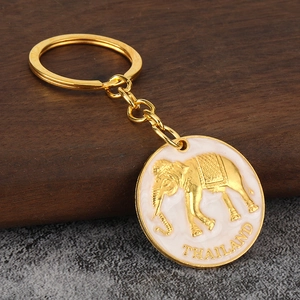Detail of Thai golden elephant keychain with white enamel inlay and Thailand engraving