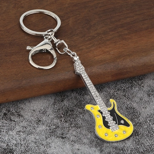 Détail du porte-clés mini guitare électrique jaune orné de strass brillants incrustés