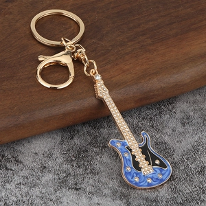 Détail macro du porte-clés guitare avec texture bleue fluide et strass étincelants