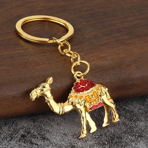 Porte-clés chameau doré avec détails en émail coloré sur un fond en bois rustique
