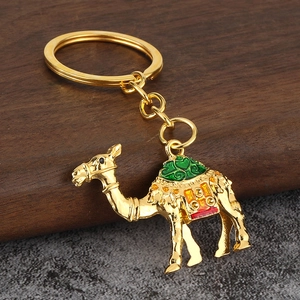Détail d'un porte-clés chameau doré en métal avec des motifs de selle en émail coloré
