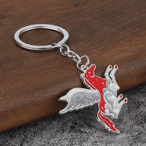 Enameled Pegasus horse keychain with star patterns and silver metal ring on wood background