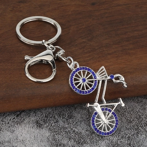 Macro detail of bicycle keychain with polished silver alloy and blue rhinestones