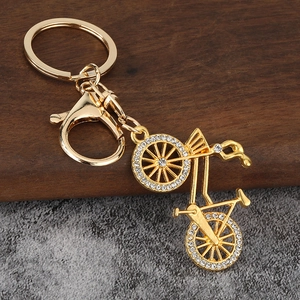 Creative gold bicycle keychain with sparkling white rhinestones on dual wheels