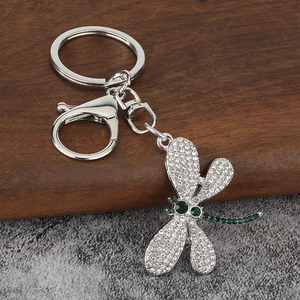 Silver dragonfly keychain with white crystals and green gemstones on a lobster clasp