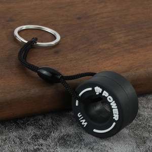 Detailed close-up of a creative PVC tire keychain with braided lanyard and metal ring