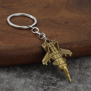 Vintage bronze fighter jet model keychain displayed on a rustic wood stand