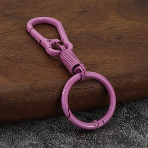 Purple zinc alloy car keychain with a minimalist carabiner design on a wooden background