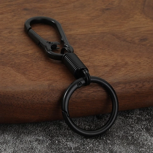 Macro detail of matte black zinc alloy carabiner keychain on a premium wood surface