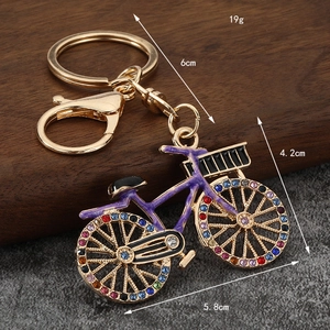 Golden bicycle keychain with purple enamel and colorful rhinestones, luxury bike accessory