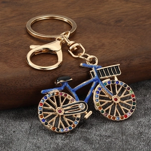 Golden luxury bicycle keychain with deep blue enamel and vibrant rainbow rhinestones