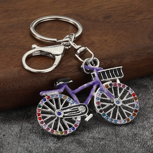 Close-up of bicycle keychain with purple enamel finish and multicolored rhinestones