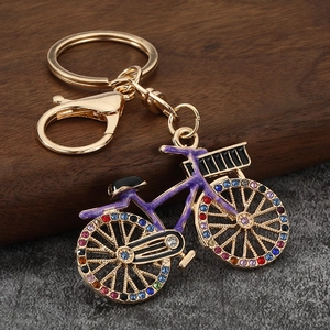 Detail of purple enamel bicycle keychain with multicolored rhinestones and gold lobster clasp