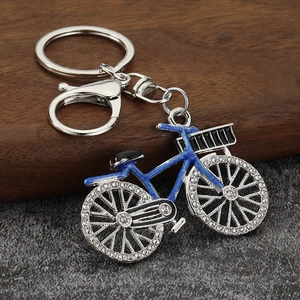 Detail of bicycle keychain with sparkling rhinestones and blue enamel on silver alloy