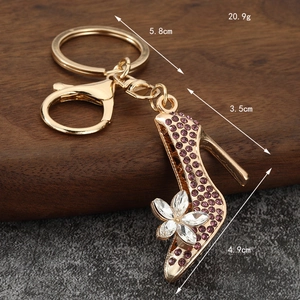 Golden high heel keychain with purple rhinestones and crystal flower detailing