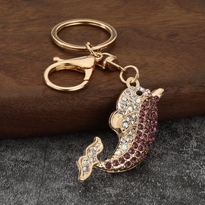 Detail of crystal dolphin keychain with purple rhinestones and gold-tone lobster clasp