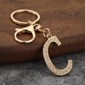 Close-up of golden letter C keychain with sparkling rhinestones and lobster clasp