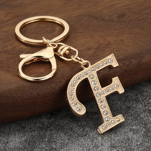 Detailed view of a gold-plated letter F keychain charm with sparkling rhinestones