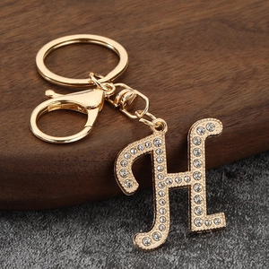 Close-up of golden letter H keychain charm with sparkling rhinestones and lobster clasp