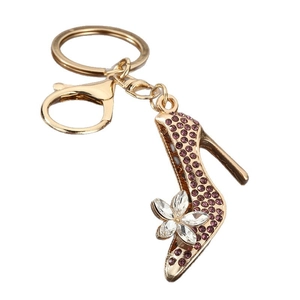 Golden high heel keychain featuring purple crystals and a lobster clasp on white background