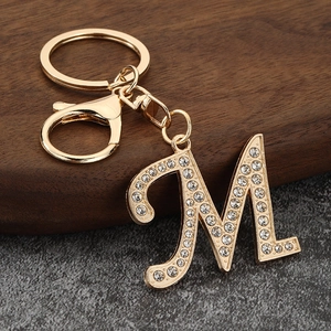 Close-up of golden letter M keychain with sparkling rhinestones and lobster clasp
