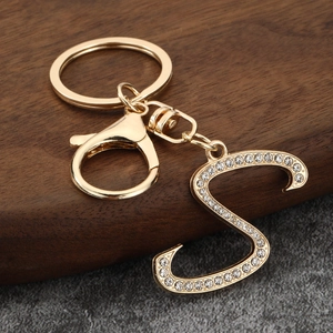 Macro detail of gold-plated letter S keychain with sparkling rhinestone inlay and lobster clasp