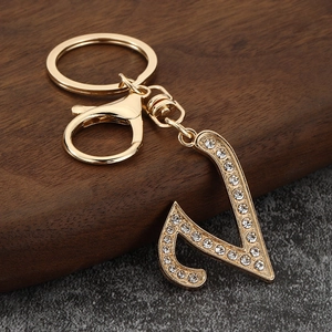 Detailed close-up of a gold-plated letter N keychain featuring sparkling crystal rhinestones