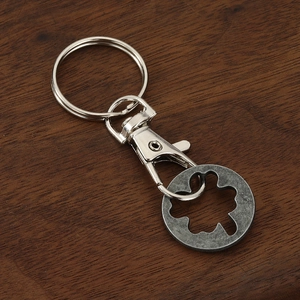 Detailed view of zinc alloy clover cart token keychain on a dark wooden background