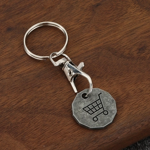 Einkaufswagen-Token-Schlüsselanhänger aus Zinklegierung auf Holzoberfläche