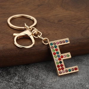 Macro detail of golden letter E keychain encrusted with colorful vibrant rhinestones