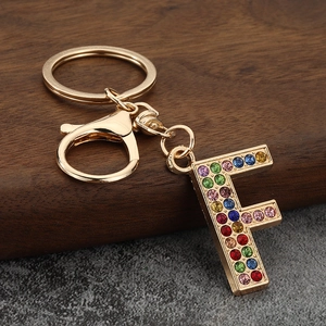 Macro detail of gold letter F keychain with colorful rhinestones and lobster clasp