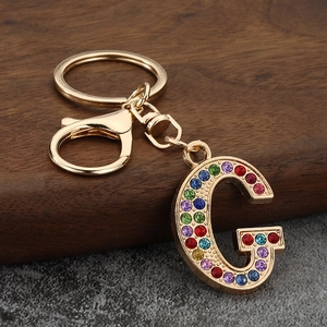 Macro view of colorful rhinestone letter G keychain with gold lobster clasp and ring