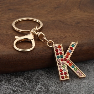 Macro view of crystal encrusted letter K keychain with colorful rhinestones on gold metal