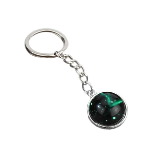 Luminous Sagittarius constellation keychain with green starry glass pendant on white background