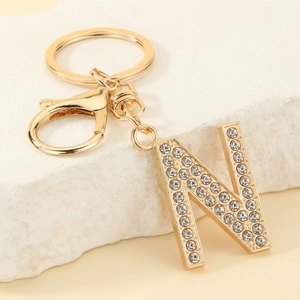 Detailed close-up of golden letter N keychain encrusted with sparkling rhinestones