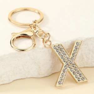 Detail of a gold letter X keychain with sparkling rhinestones and lobster clasp