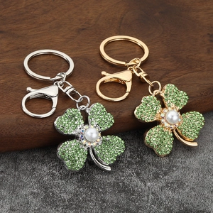 Portachiavi a quadrifoglio con strass verdi e perla su anello metallico chic