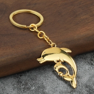 Golden dolphin keychain with polished metal finish and dual dolphin pendant design