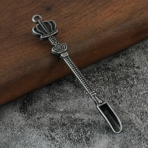 Macro view of vintage metal crown spoon with engraved textures on a rustic background