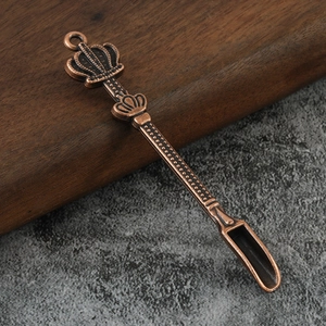 Macro detail of crown handle metal spoon with vintage copper finish and textured body