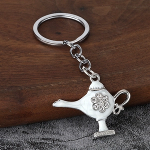 Detailed macro view of an Aladdin lamp keychain with white enamel and sparkling rhinestones