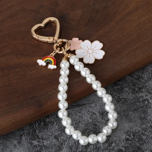Charming pearl keychain with golden heart clasp, rainbow cloud and floral pendants