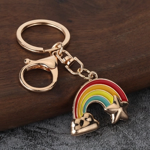 Rainbow and gold star keychain pendant with lobster clasp on a modern stone backdrop