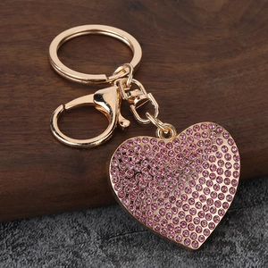 Detailed macro view of heart-shaped keychain with pink crystals and gold plating