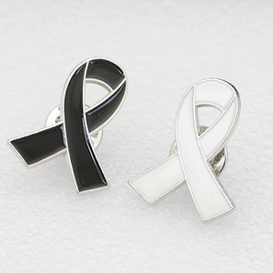 Détail des broches ruban en émail noir et blanc avec bordures en métal argenté