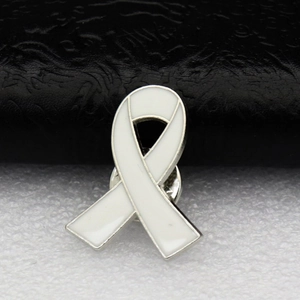 Gros plan d'une broche ruban en émail blanc avec bordure argentée pour causes caritatives