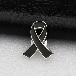 Broche en émail ruban noir avec bordure argentée pour sensibilisation sur fond cuir