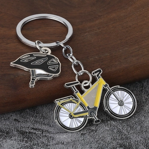 Detail of metal keychain featuring yellow mountain bike and black cycling helmet charms